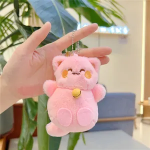 Dettaglio portachiavi a forma di gatto in peluche rosa con campanellino dorato