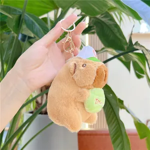 Detalle de llavero de peluche Capibara con gorra de béisbol y bola bordada
