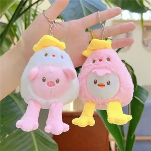 Cute long-legged chick and pig plush keychains with silver metal chains on green plants