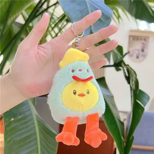 Macro view of cute plush duck keychain with green avocado coat and orange feet held in hand
