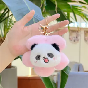 Close-up of plush panda flower keychain with pink petals and gold metal clip detail