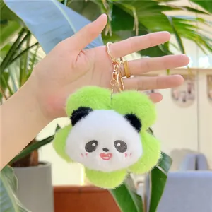 Close-up of plush panda head keychain with green flower collar and gold metal clasp