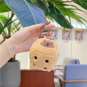 Gros plan du pendentif dé en peluche capybara douce avec broderie et cordon en spirale