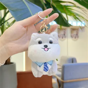 Détail de la peluche Shiba Inu avec cravate bleue et fermoir mousqueton métallique