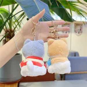 Close-up of plush Shiba Inu dog keychains held in hand to show the actual size and soft texture