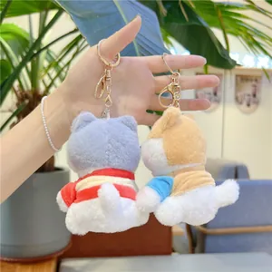 Detail of plush dog keychains with soft fabric and gold-plated metal lobster clasps