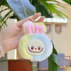 Close-up of a colorful tie-dye plush rabbit keychain with a golden metal ring clip