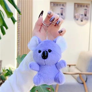 Detail of purple plush koala pendant keychain held in hand with soft fur texture