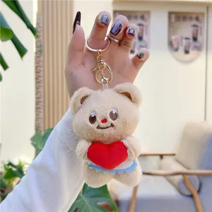 Close-up of butter bear plush keychain with red heart and golden metal ring