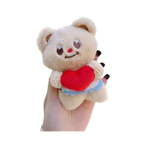 Plush brown bear keychain with red heart and blue lace trim on white background