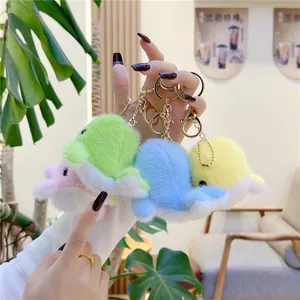 Detail of plush dolphin keychains in blue and pink with soft fur and metal clips