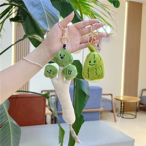 Hand holding cute plush broccoli and green vegetable keychains with golden metal hooks