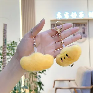 Close-up of yellow plush cloud pendants with embroidered smiley face and metal keychain
