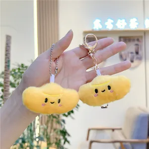 Detail of soft yellow plush charms with cute embroidered faces and metal keyrings