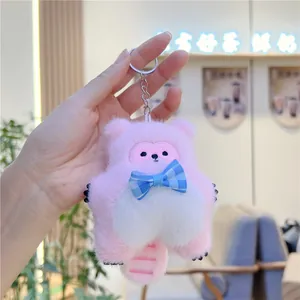 Close-up of pink plush cat keychain with a striped tail and blue checkered bow tie