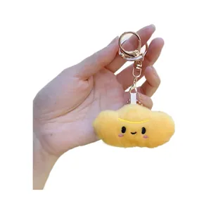 Plush yellow cloud keychain with embroidered smile and rose gold metal lobster clasp