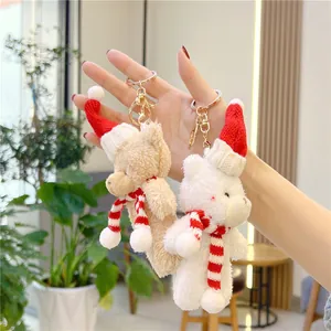 Christmas plush bear keychains with red Santa hats and scarves in a warm festive setting