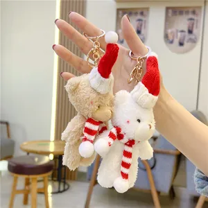 Close-up of two plush Christmas bears with red hats and scarves held in hand for size