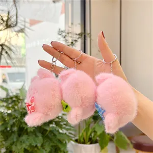 Drie schattige roze pluche varkenssleutelhangers met kleurrijke strikjes en ringen