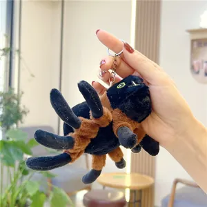 Detailed close-up of a plush black spider keychain with soft texture and metal ring