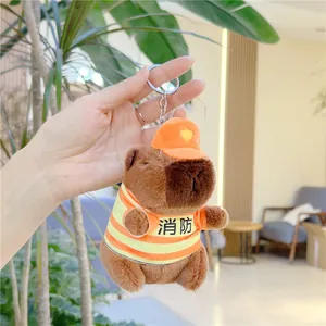 Close-up of capybara plush keychain wearing a striped firefighter vest and orange hat