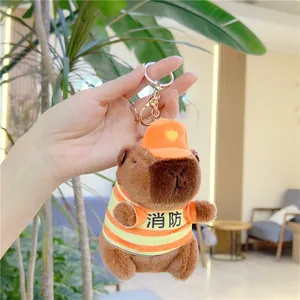 Close-up of plush capybara keychain wearing a mini orange firefighter uniform with silver hook