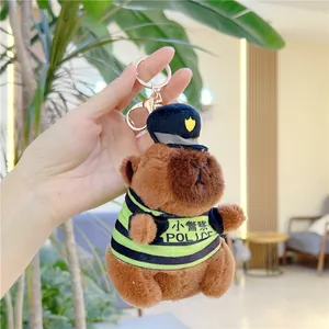 Detail view of a plush capybara wearing a police hat and vest with a metal keychain hook