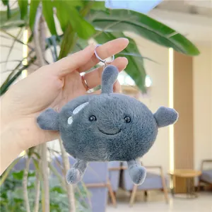 Close-up of a cute plush frozen pear keychain with soft grey fur and embroidered smile