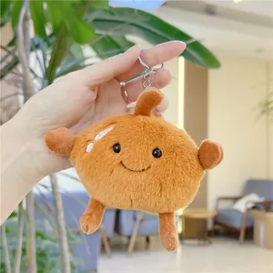 Detail of creative brown frozen pear plush keychain with cute embroidered smiling face