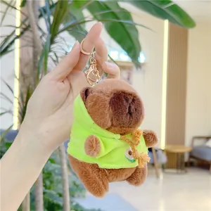 Macro detail of plush capybara keychain wearing a green avocado hoodie with gold clasp