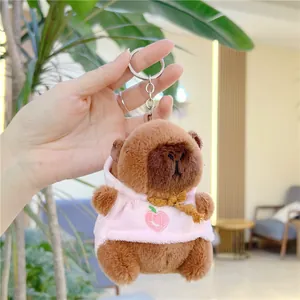 Detail of Capybara plush keychain wearing pink hoodie with peach embroidery and silver ring