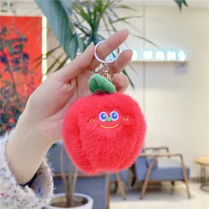 Close-up of red mink fur apple plush keychain with cute embroidered smiling face
