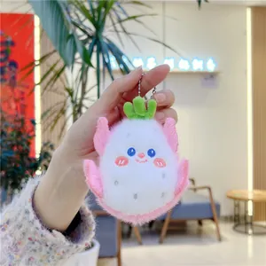 Close-up of cute plush dragon fruit keychain with embroidery and soft pink fur