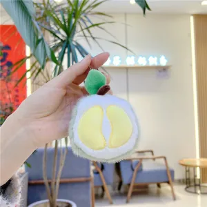 Close-up of a creative plush durian keychain with soft green fur and yellow embroidery
