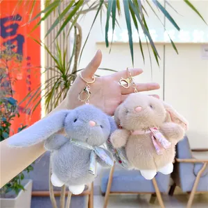Cute plush lop-eared bunny keychains in grey-blue and khaki with floral bow ties