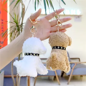 Detail of white and brown plush dog keychains with gold metal hooks and star collars