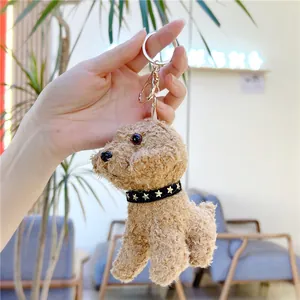 Detailed close-up of a brown curly plush teddy dog keychain with a star pattern collar