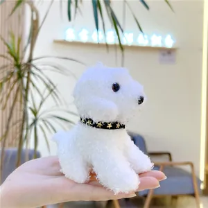 Close-up of a palm-sized white plush puppy toy with a black star collar decoration