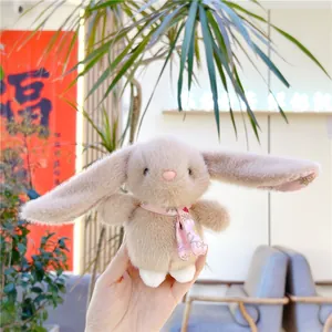 Close-up of a plush rabbit doll with floral patterned ears held in a hand