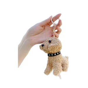 Cute brown plush teddy dog keychain with curly fur and a star collar on white background