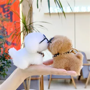 Detail van pluche puppy-sleutelhangers met brillen en halsbanden in wit en bruin
