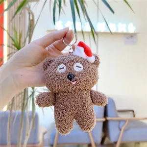 Detailansicht eines braunen Teddybär Schlüsselanhängers mit Weihnachtsmütze und weichem Fell
