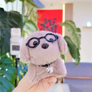 Close-up of plush puppy keychain featuring black glasses and a small metal bell