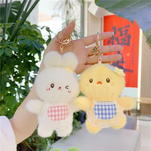 Cute plush rabbit and chick charms with lace bibs and gold metal keychains in hand