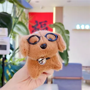 Close-up of a plush brown dog keychain with black glasses and silver bell charm