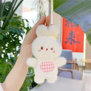 Detail of cute white plush bunny charm with pink checkered bib and golden bead chain