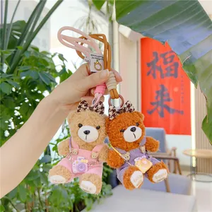 Plush teddy bear charms in pink and brown with corduroy overalls and mini cameras