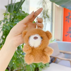 Detalle de llavero de osito de peluche marrón con suave pelo largo y cadena de metal