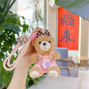 Detail of plush bear keychain with pink corduroy overalls and mini camera accessory