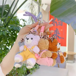 Detailed close-up of cute plush bear pendants in purple, pink and khaki with overalls